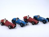 four toy cars that are lined up on a white surface