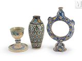 three vases and a cup on a white surface