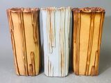 trois vases posés côte à côte sur une table