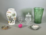 un vase en verre vert posé à côté d'un autre vase vert et d'autres objets