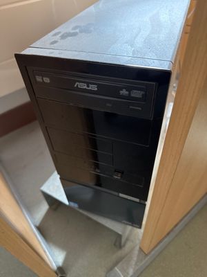 a black computer sitting on top of a wooden desk