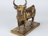 brass statue of a bull on a marble base on a white background