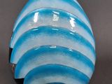 a blue and white vase sitting on a gray surface