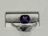 une bague sertie d'une pierre violette, dans un écrin