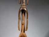 une image représentant une statue en bois d'une femme au long cou