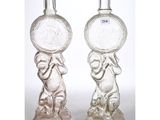 two clear glass bottles with a monkey holding a coin on top of them