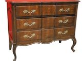 a chest of drawers with a red top and gold handles