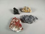 four different colored crystals are arranged on a white surface