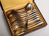 six cuillères en argent dans une boîte avec un étui en cuir