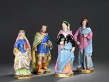 trois figurines représentant des hommes et des femmes vêtus de costumes médiévaux