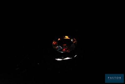 un gros plan d'une bague dans l'obscurité, éclairée par une source lumineuse