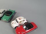 several toy cars are lined up in a row on a gray surface