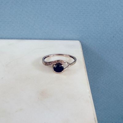 a close up of a silver ring with a blue stone