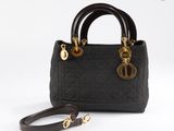 un sac à main noir avec des finitions dorées et une bandoulière marron
