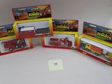 quatre jouets emballés, dont un camion de pompiers, un camion et un camion de pompiers
