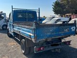 a blue truck that is parked in a lot