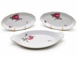 three white plates with pink roses on them sitting next to each other