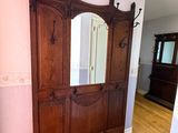 a wooden cabinet with a mirror on it in the corner of a room