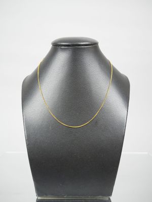 a black mannequin with a gold chain on it