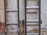 deux échelles appuyées contre le mur, l'une à côté de l'autre