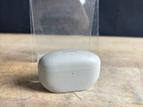an apple airpods are sitting on a wooden table with a clear box