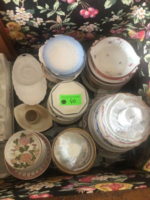 une valise remplie d'assiettes et de bols posée par terre