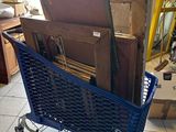 a blue shopping cart full of boxes in a room