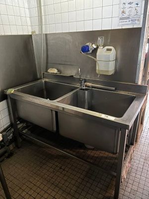 two sinks in a public bathroom with a faucet