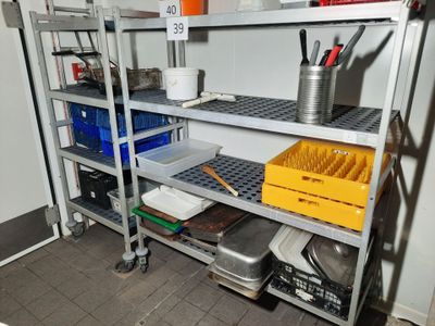 une étagère métallique sur laquelle sont disposés de nombreux objets divers