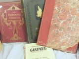 three books sitting on a bed next to a basket