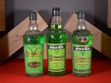 three bottles of alcohol are sitting on a red table
