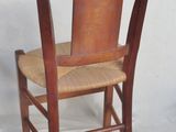 a wooden chair with a woven seat on a white background