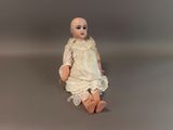 a doll that is sitting on the floor with a white dress