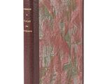 un vieux livre à la couverture rouge posé sur une surface blanche