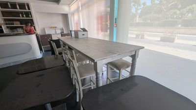 une table et des chaises dans une pièce avec une grande fenêtre