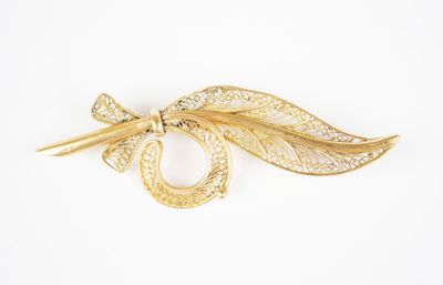 a close up of a brooch with a leaf on it