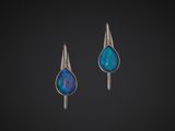 a pair of silver earrings with blue oplite in the shape of a tear