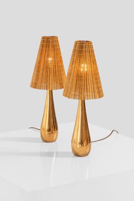 two gold lamps on a white table with a white background