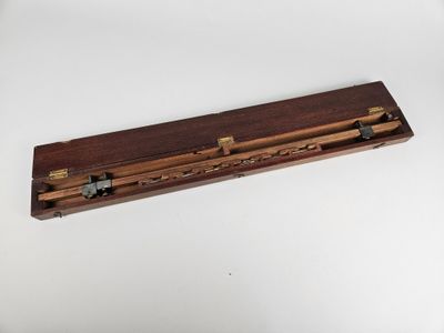 deux crayons dans un porte-crayons en bois posé sur une surface blanche