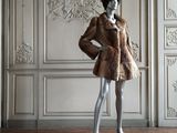 a mannequin dressed in a fur coat in a room