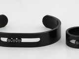 a close up of a pair of black bracelets on a white surface