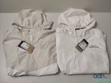 deux vestes blanches, encore étiquetées, posées sur une table