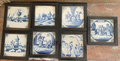 six framed blue and white tile pictures on a brick wall