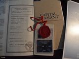 a red wax seal sitting on top of a book next to a pair of scissors