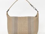 a beige leather bag with a braid handle and a zipper closure