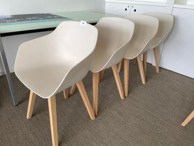 four white chairs sit in front of a table with a book on top of it