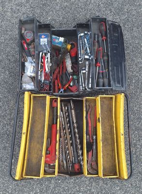 de nombreux outils dans une boîte à outils posée par terre