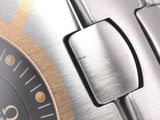 close up of a watch with a black face and a gold bezel