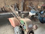 un petit tracteur et une petite tondeuse dans un garage