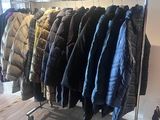 de nombreuses vestes suspendues à un portemanteau dans un magasin de vêtements